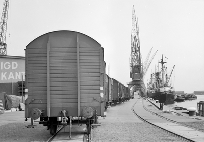 849025 Afbeelding van goederenwagens op een kade in de Coenhaven (Vereenigd Cargadoorskantoor) te Amsterdam.